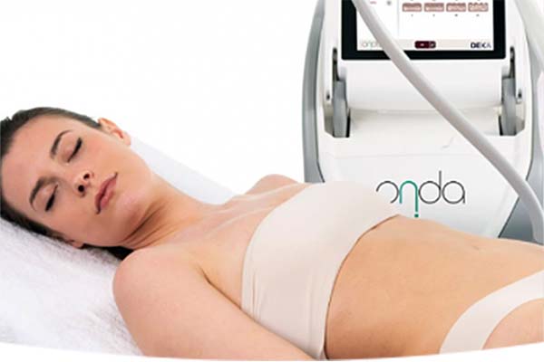 Frau liegt entspannt in einem medizinischen Behandlungsraum, neben einem Gerät mit dem Schriftzug ONDA.